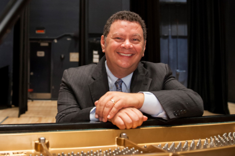 Alan Terricciano Man smiling and seated by piano